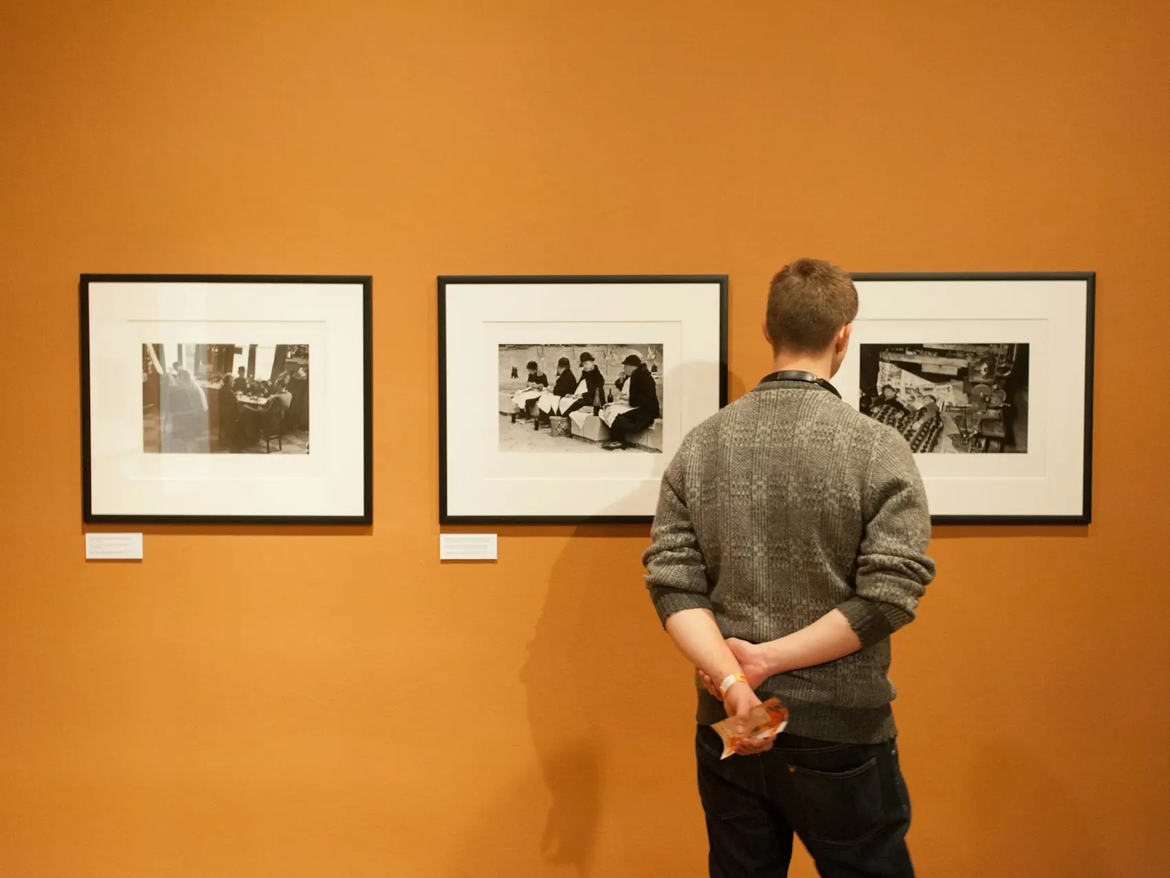 man in gray sweater standing near wall
